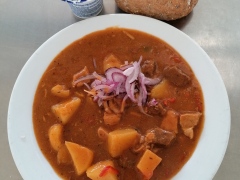 Uherský guláš (vepř.+ hov. maso, brambory, rajčata, paprika), pečivo (sójová bulka)